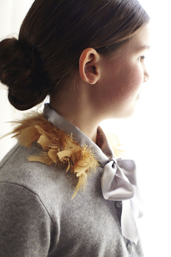 A flower girl wears the custommade feather collar