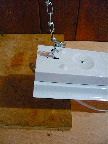 The same type of 'S' hooks are at the end of the chain and go through notches on the top of the light to suspend it over the bench. This makes raising and lowering the light easy.