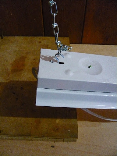 The same type of 'S' hooks are at the end of the chain and go through notches on the top of the light to suspend it over the bench. This makes raising and lowering the light easy.
