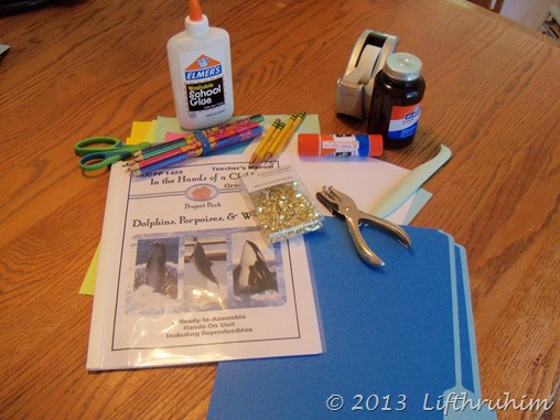 Picture of supplies needed such as bonefolder, file folder and glue