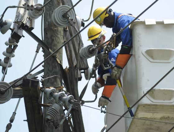 Utility workers secured power lines on a pole in Springfield, Va., on Sunday, 1 July 2012. Cliff Owen / Associated Press