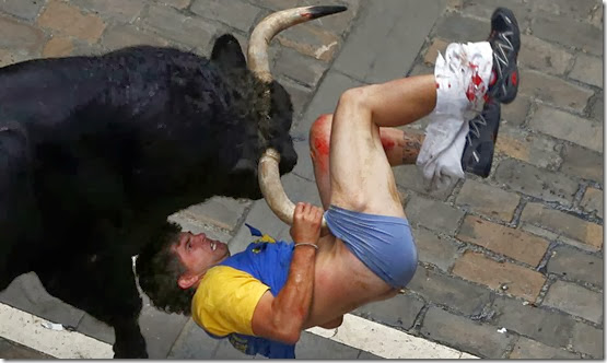 Diego Miralles gets gored by a bull on Estafeta street during the sixth running of the bulls of the San Fermin festival in Pamplona July 12, 2013. The runner, a 31-year-old man from Castellon, Spain, was gored three times. REUTERS/Susana Vera (SPAIN)<br />