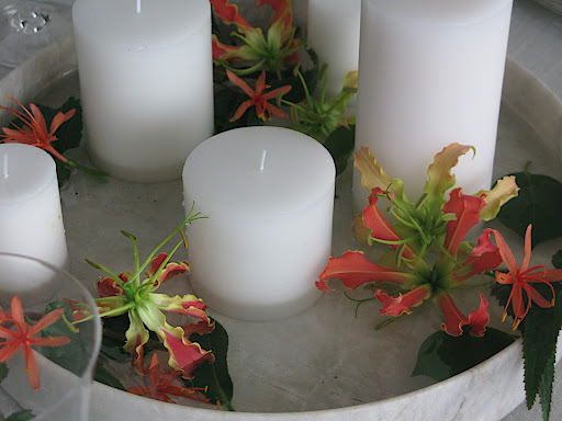 Here, a close-up of the table centerpiece: a low marble vessel filled with water, pillar candles, and flowers.