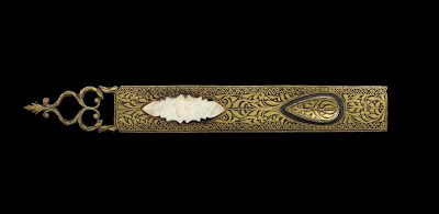 Penrest | Origin:  Turkey | Period: 18th-19th century  Ottoman period | Details:  Not Available | Type: Ferrous base metal with gold decoration, tooth ivory | Size: H: 0.4  W: 14.3   D: 1.8  cm | Museum Code: S1991.14 | Photograph and description taken from Freer and the Sackler (Smithsonian) Museums.