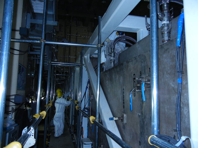 Workers assemble the side part of a skid in the Water Treatment Facility at the Fukushima Daiichi Nuclear Power Station, 9 June 2011. TEPCO