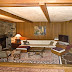 The recessed living room features a custom made leather couch, river rock fireplace and flat screen television.
