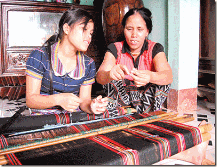 Mai Thi Hop teaching ‘Zeng’ weaving to a young girl