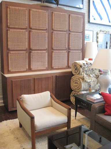 This large 1950s English cerused oak and rattan cabinet in a rustic modern style stands more than 8 feet high. Bottom part has four doors and interior shelves. I love the wicker panels that rest on a slab of travertine.