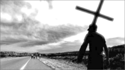 c0 man carrying cross on a highway