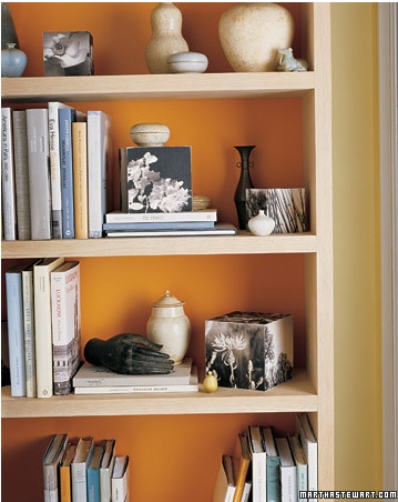 Martha Stewart Living editors love to paint the back of book shelves and this case is not exception. Orange makes the items pop.