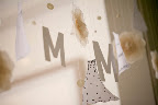I sketched little dresses to hang on the garland along with the letter M, buttons, and flowers. Paper for the decorations is from Paper Presentation.