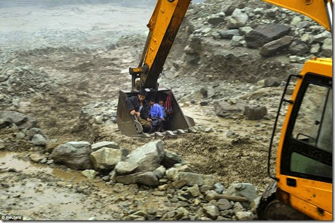 An excavator is used to move villagers away from a flooded area during heavy rainfall in Yingxiu, Wenchuan county, Sichuan province, China, July 10 An excavator is used to move villagers away from a flooded area during heavy rainfall in Yingxiu, Wenchuan county, Sichuan province, China, July 10
