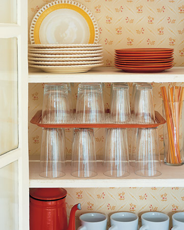 Increase cupboard space by using a serving tray as a shelf divider.
