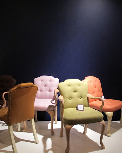 The brightly colored chairs pop against a navy background, while the wood details keep everything grounded.