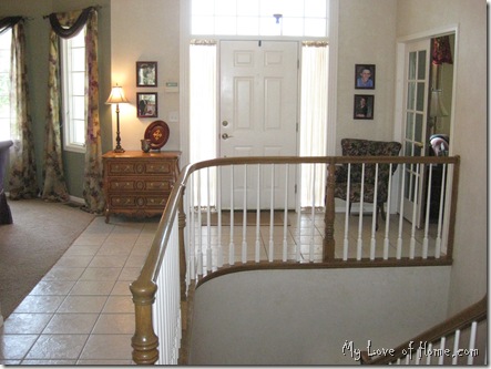 Foyer, entry, spindl stairs, medium wood, tile floor, unique chest