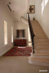 La escalera de mármol con baranda de hierro y madera nace en el hall de acceso y lleva a la master suite en la planta alta. A sus pies, un gran kilim antiguo traído de Turquía delante de un mueble tailandés de Mayflower. Sobre él, dos vinchas mapuches de colección y, en la pared, un antiguo awayo del Altiplano que se compró en Tierra Adentro. Gentileza: Revista D&D.