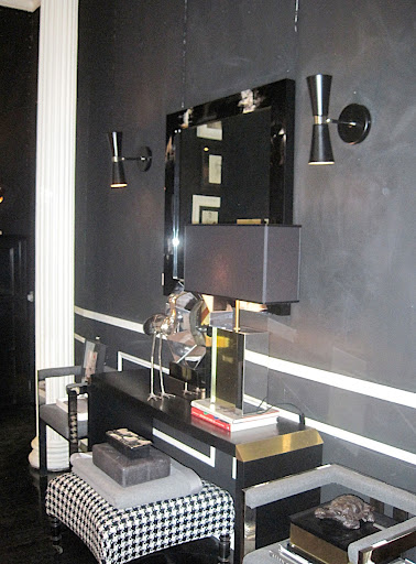 The dark wall with the white trim is a great backdrop for this mirror.  I was considering sconces of a similar style for my bedroom.