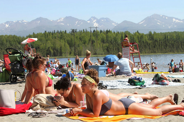 This photo taken Monday, 17 June 2013, shows people sunning at Goose Lake in Anchorage, Alaska. Parts of Alaska are setting high temperature records as a heat wave continues across Alaska. Temperatures are nothing like what Phoenix or Las Vegas gets, but temperatures in the 80s and 90s are hot for Alaska, where few buildings have air conditioning. Photo: Mark Thiessen / AP Photo