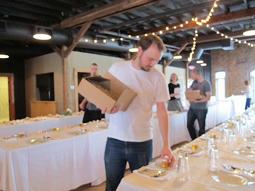 The groom places honey jars around a table.