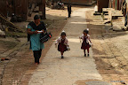 Mother and 2 little girls coming home from school