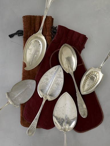 Large late-19th-century serving utensils, used for pies and pastries, are ornately decorated and come in a variety of imaginative shapes, including a helmet, far right. Large late-19th-century serving utensils, used for pies and pastries, are ornately decorated and come in a variety of imaginative shapes, including a helmet, far right.