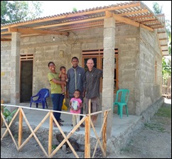 Sinta with her husband Apoli and 2 neices proudly standing outside their newly finished home. Sinta with her husband Apoli and 2 neices proudly standing outside their newly finished home.