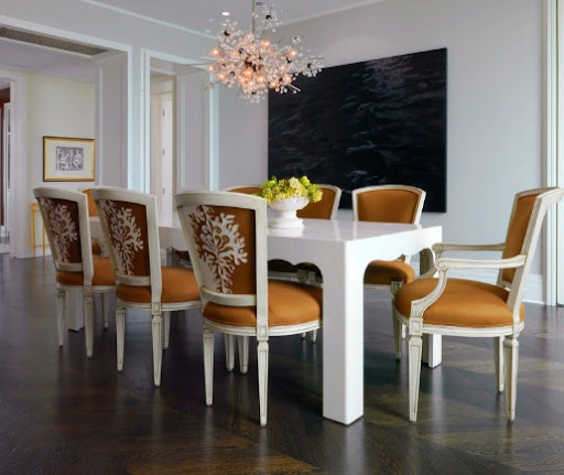A set of caramel dining chairs surround a glossy white table. (cocokelley.blogspot.com)