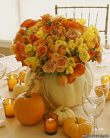 A white-pumpkin shell becomes the vase for an arrangement of roses, daffodils, ranunculuses, calla lilies, tulips, and hypericum berries in fall colors.