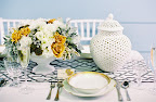 Blanc de Chine vases along with gorgeous gold-trimmed fine china, silver utensils, and a chain-link table runner helped create a beautiful tablescape.