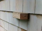 I made blocks out of cedar and attached them to the house. The trellis is mounted on the blocks to ensure that there is some space between the trellis and exterior of the house.