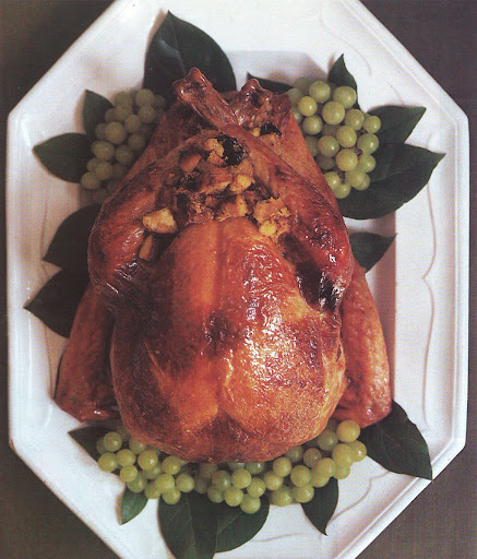 The turkey stuffed with corn bread and sourdough bread, is served on a platter surrounded by green grapes and bay leaves; in the last half hour of cooking, it is glazed several times with a mixture of ginger, maple syrup and butter. The turkey stuffed with corn bread and sourdough bread, is served on a platter surrounded by green grapes and bay leaves; in the last half hour of cooking, it is glazed several times with a mixture of ginger, maple syrup and butter.