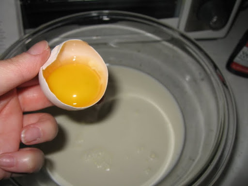 Add two egg yolks to the milk and cream in the bowl.