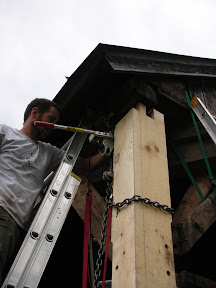 The new corner post is lifted into place.