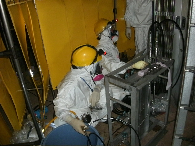 Workers install temporary pressure indicators for the Unit 1 reactor at the Fukushima Daiichi Nuclear Power Station, 3 June 2011.