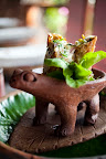 An appetizer roll filled with delicious fresh chicken and herbs rests in my favorite frog dish.