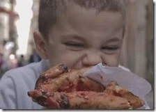 Un bambino mangia una pizza