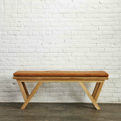 Bench of frame-oiled ash with brass inlay. The cushion is Royce Brandy German cowhide tanned in Italy.