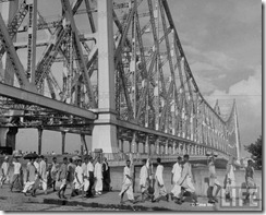 Evacuees streaming across the Howrah Bridge on their way to the railway station in hopes of escaping the city after bloody rioting between Hindus and Muslims