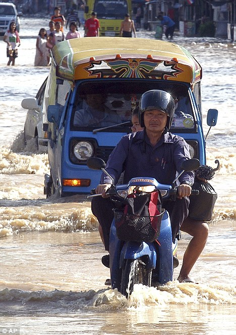 Trouble ahead: A motorcyclist tackles the floods in Thailand's Songkhla province, 4 January 2012. AP