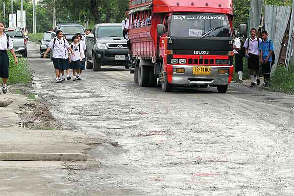 Thai Raman Road in Klong Sam Wa district is pockmarked with potholes and turns into a sea of mud when it rains—and a dustbowl when it does not. The road has been left unrepaired for years, causing untold bother to pedestrians, passengers and motorists alike. SURAPOL PROMSAKA NA SAKOLNAKORN / bangkokpost.com