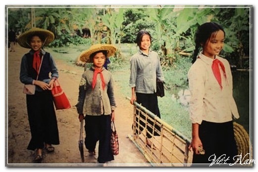 Các bạn học sinh nữ ở nông thôn miền Bắc trong ngày đầu đến trường, với trang phục mũ rơm chống đạn bom cùng chiếc khăn quàng đỏ.