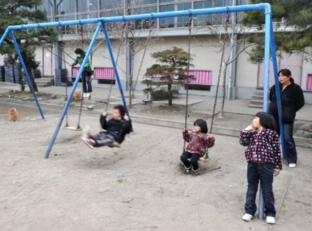 Children play outside of an evacuation centre at Sendai city in Miyagi prefecture. Japan's Fukushima city said on 14 June 2011 that it would hand radiation dosimeters to 34,000 children to gauge their exposure from the crippled nuclear power plant about 60 kilometres (40 miles) away. AFP / Kim Jae-Hwan