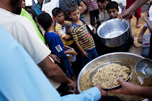 Syrian refugees wait to receive food from a makeshift kitchen in a temporary refugee camp near the Al-Salama crossing between Syrian and Turkey on September 8, 2012. Fighting for control of a key army base in Aleppo raged, as Russia tried to revive a divisive accord on ending the bloodshed that calls for a government of unity in Syria. AFP PHOTO/ACHILLEAS ZAVALLIS