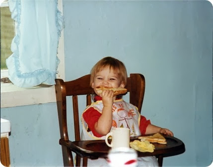Andrea with sandwich in highchair