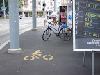La piste cyclable de la plaine de Plainpalais : la multi-usage. Stationnement pour les puciers, endroit stratégique pour les pylône du tram, endroit idéal pour les affiches de votation et parking pour cycliste. Photo: Gabriele