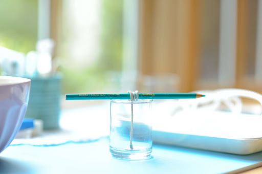 Step 4: Tie the wick around a pencil to keep it upright, and lay the pencil across the candleholder. Step 4: Tie the wick around a pencil to keep it upright, and lay the pencil across the candleholder.