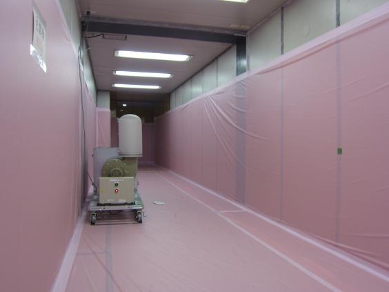 Hallway and a local ‘exhauster’ in the rest area in front of Main Anti-Earthquake Building, June 2011. Walls and floors have been covered with a pink fabric, presumably for quick disposal after contamination. TEPCO