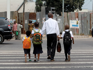 Un parent viens de récupérer ses enfants à l’école le 5/9/2011 à Kinshasa, lors de la rentrée scolaire 2011-2012. Radio Okapi/ Ph. John Bompengo