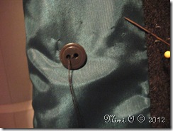 Button is sewn in on the underside while button sewn to the front.