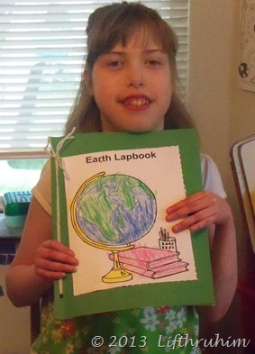 Supergirl proudly displays her Earth notebook